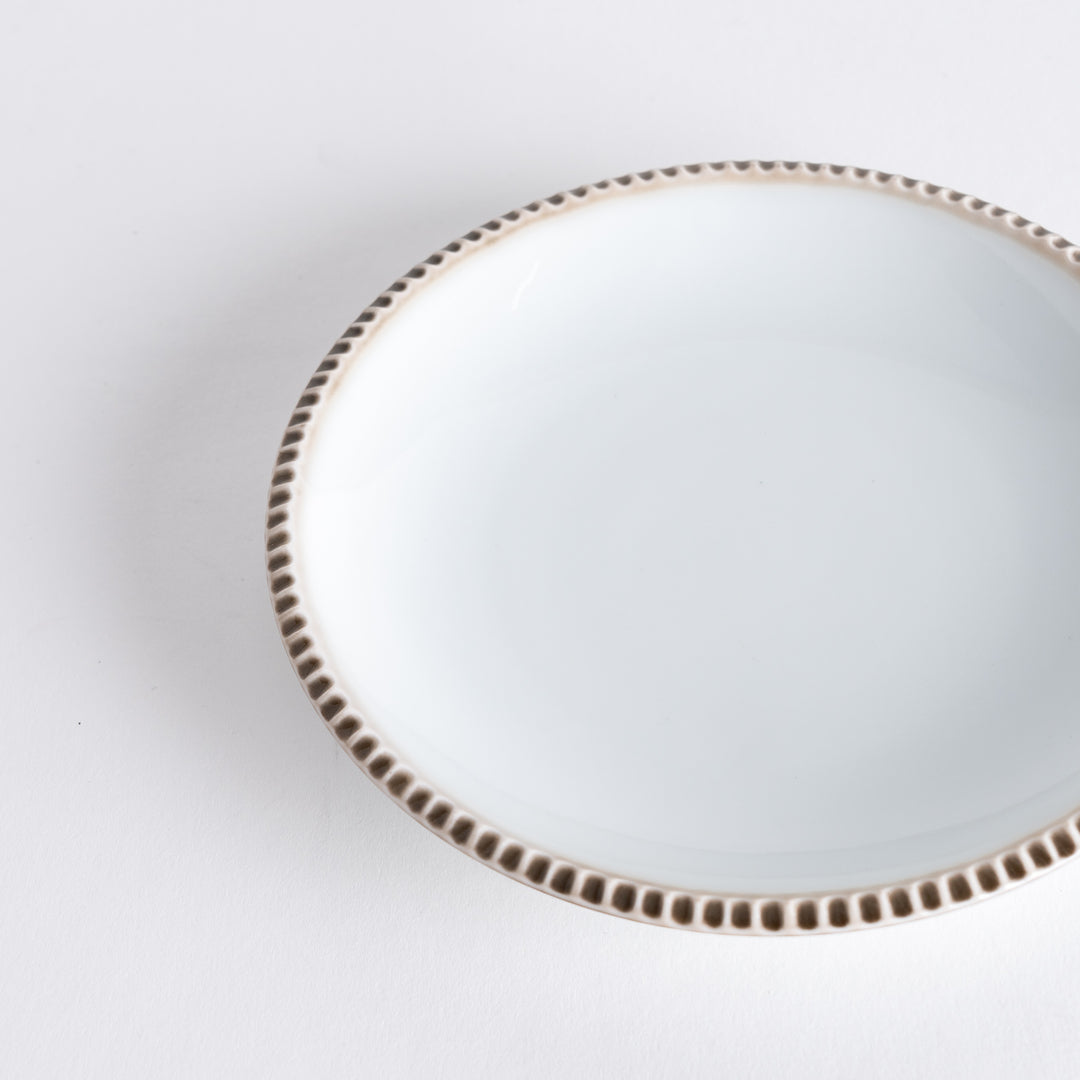 A round white dessert plate with a rustic scallop-edged border. The border comes in blue, brown, and olive.