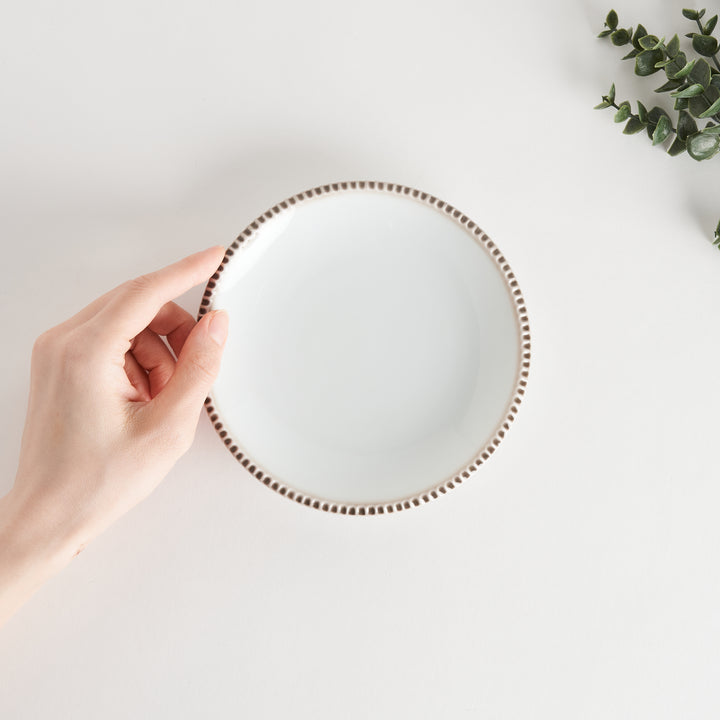 A round white dessert plate with a rustic scallop-edged border. The border comes in blue, brown, and olive.