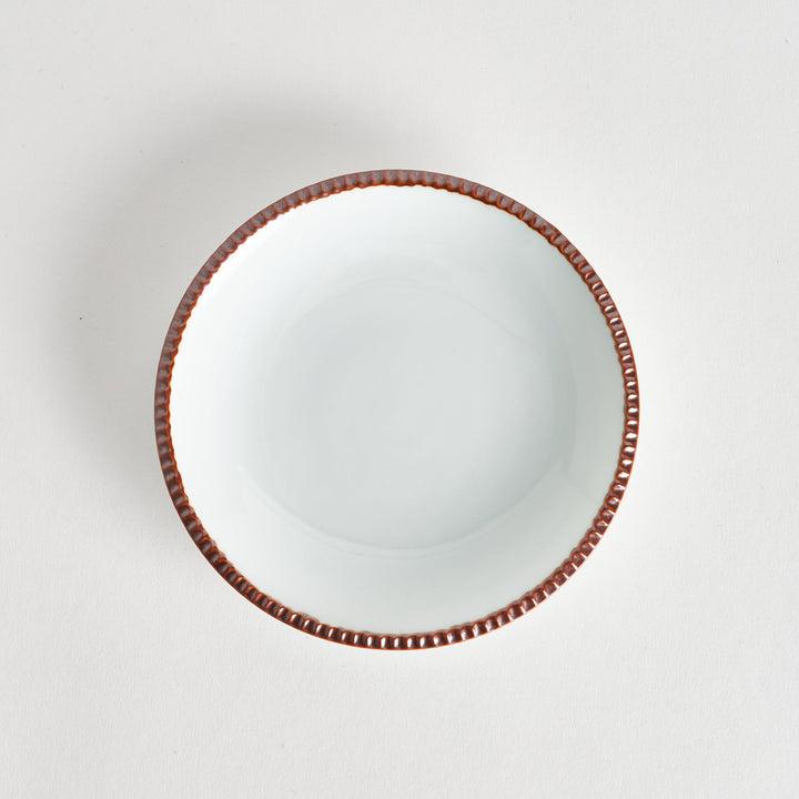 A round white dessert plate with a rustic scallop-edged border. The border comes in blue, brown, and olive.