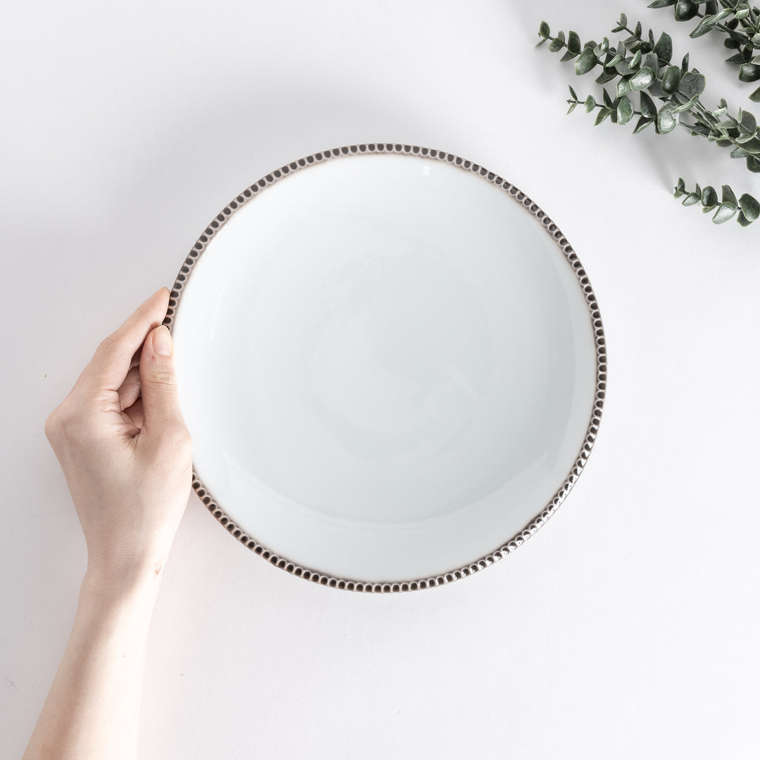 A small porcelain condiment bowl adorned with a blue floral pattern and soft brush strokes.