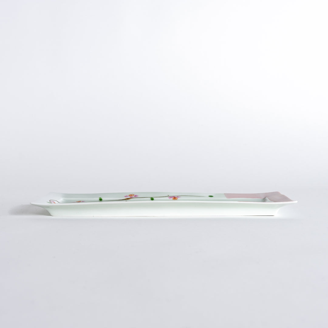 Side view of a rectangular plate featuring cherry blossoms, emphasizing its slim profile and elegant design.