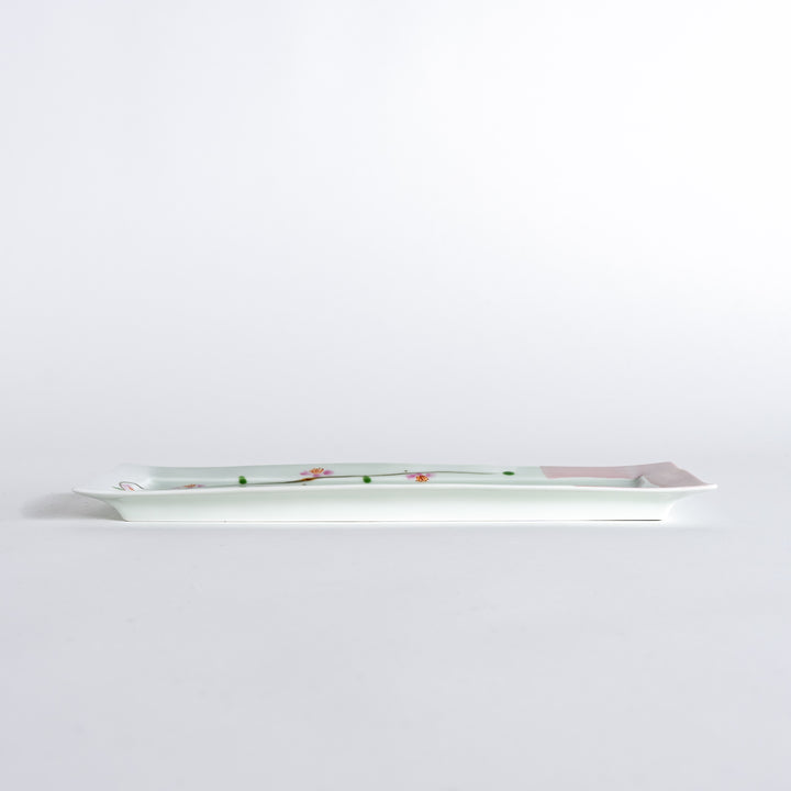 Side view of a rectangular plate featuring cherry blossoms, emphasizing its slim profile and elegant design.