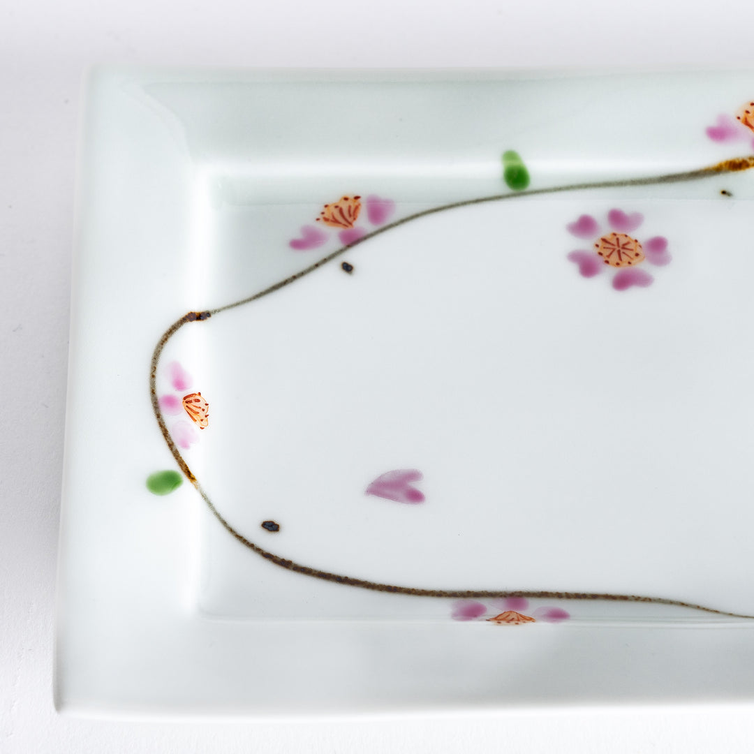 Close-up of the cherry blossom pattern, showing intricate pink flowers and green accents on the plate.