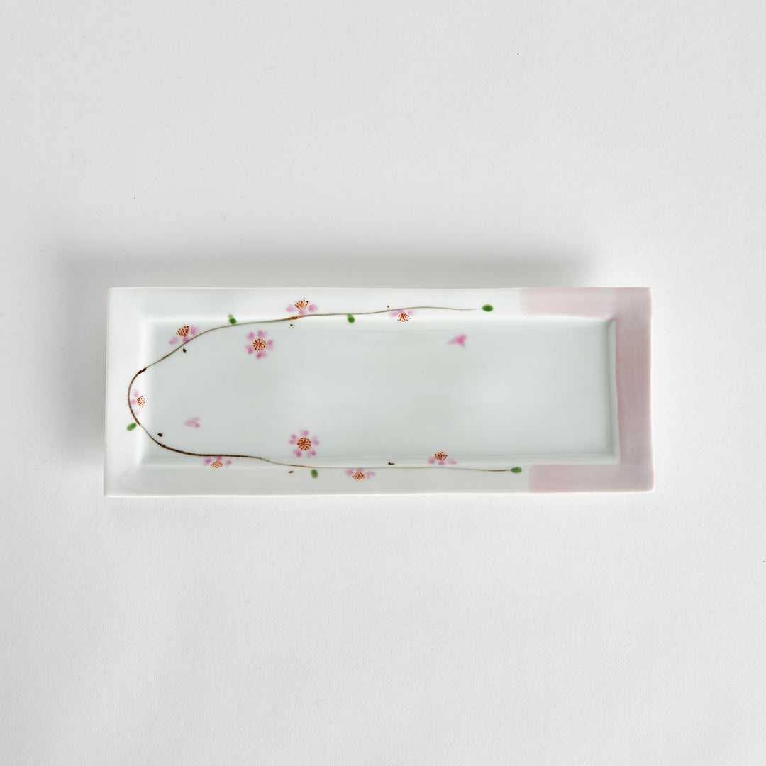 Rectangular serving plate viewed from above, featuring a delicate cherry blossom pattern along one edge with soft pink accents on the corners.