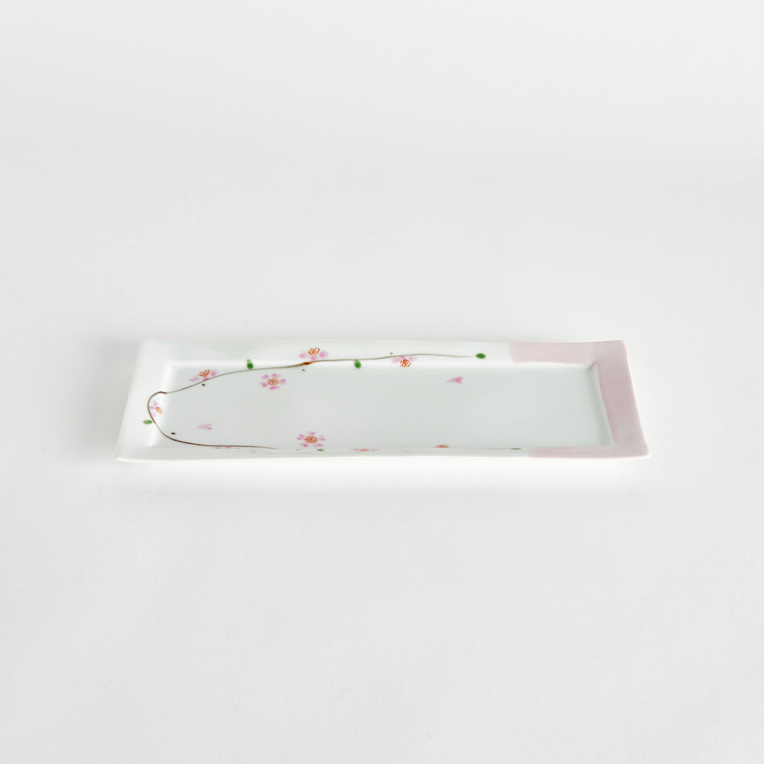 Rectangular plate with cherry blossom design, captured at an angle, highlighting its soft pink and floral details.