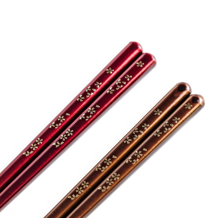 Elegant red and brown lacquered chopsticks adorned with delicate gold cherry blossom motifs, featuring a gradient of gold for added sophistication.