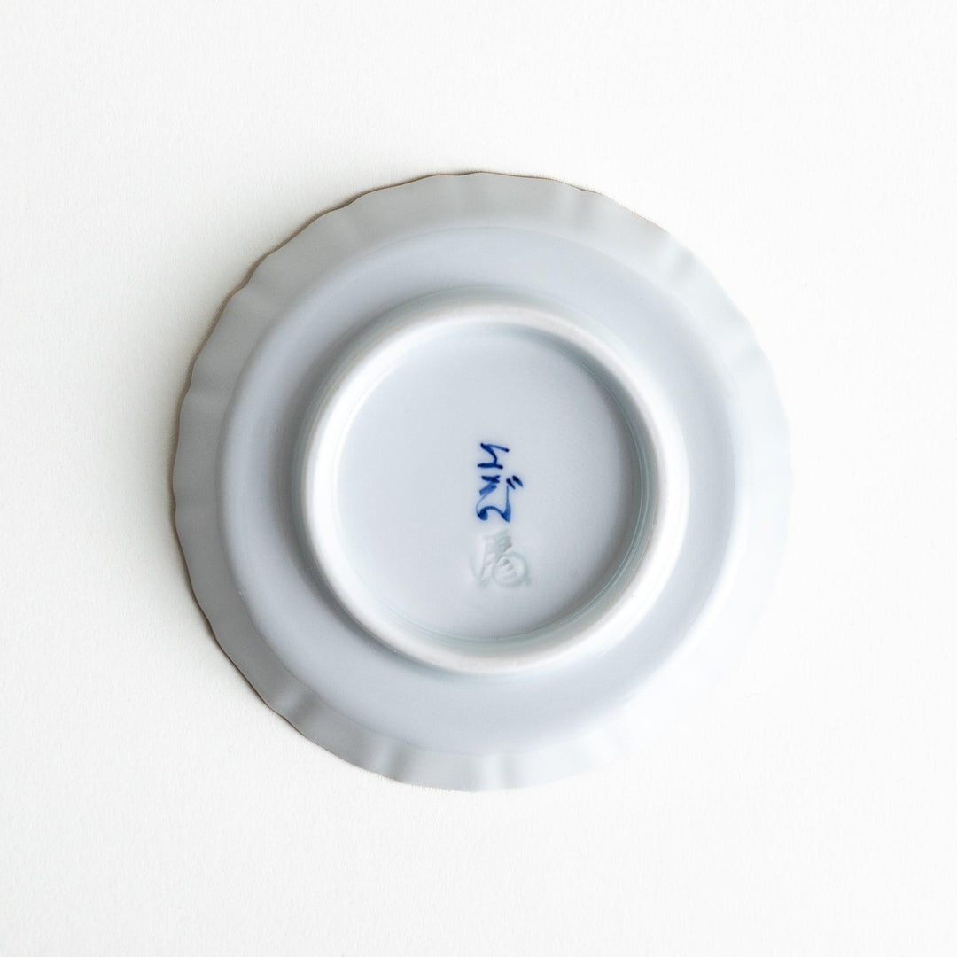 A white ceramic plate adorned with a red floral design and an outline of Mount Fuji in the background.