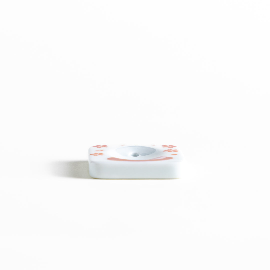 Square ceramic incense holder featuring a delicate sakura rabbit design with pink and red accents, crafted to securely hold incense while adding a charming aesthetic.