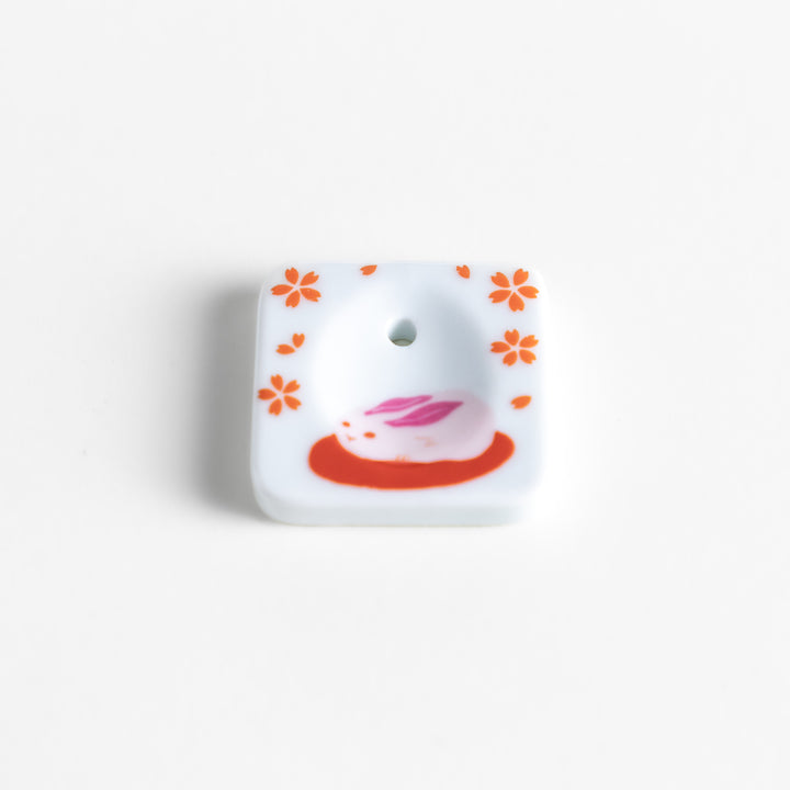 Square ceramic incense holder featuring a delicate sakura rabbit design with pink and red accents, crafted to securely hold incense while adding a charming aesthetic.