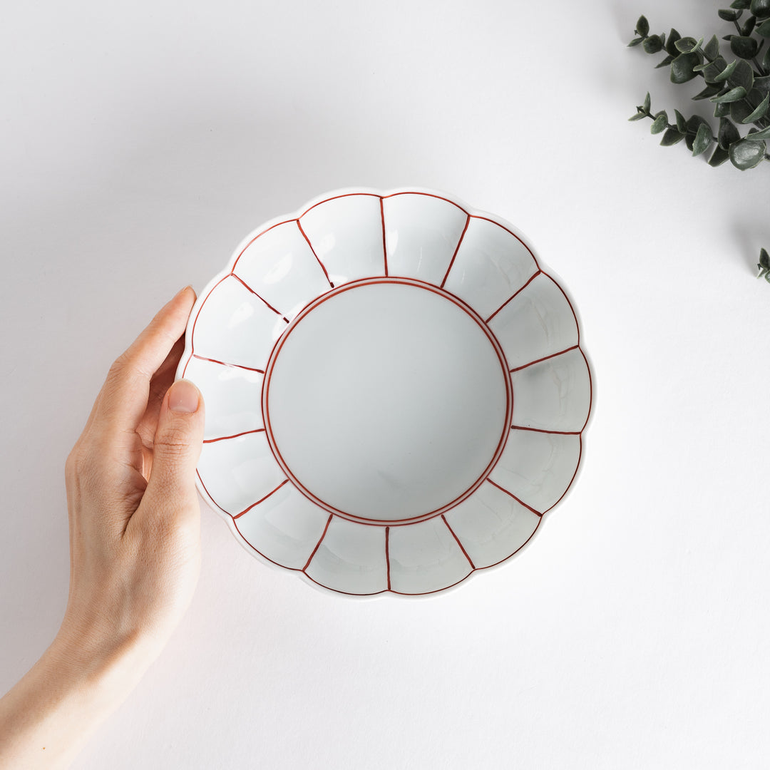 A small round dessert bowl with a delicate blue chrysanthemum pattern and scalloped edges.