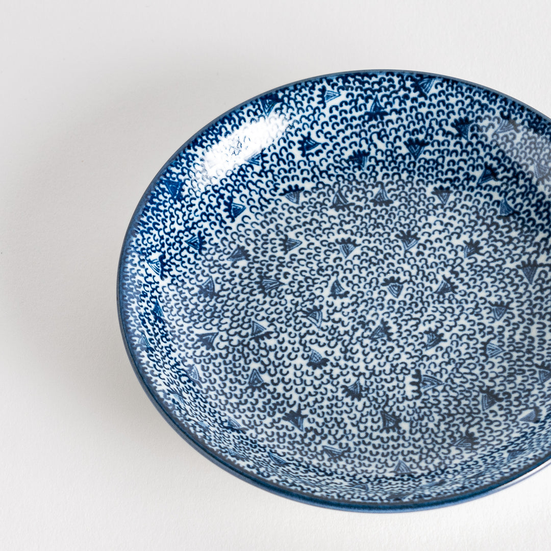 A shallow round plate with a speckled blue pattern covering the surface.