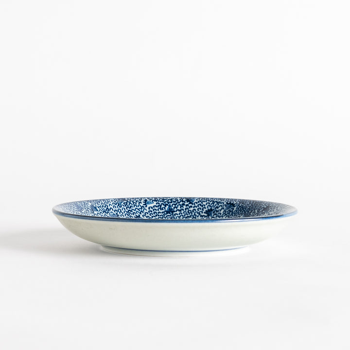 A shallow round plate with a speckled blue pattern covering the surface.