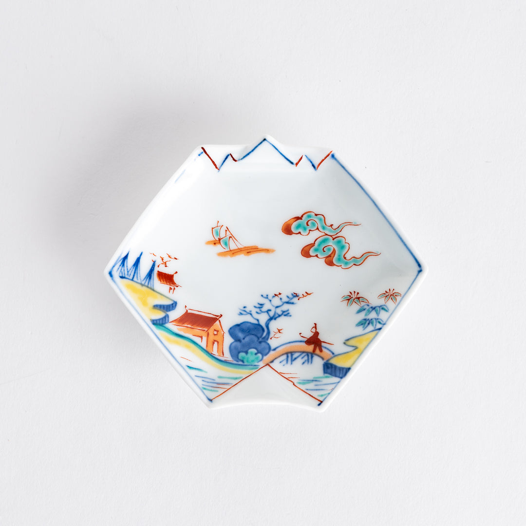 Top view of a decorative sauce dish showcasing colorful hand-painted scenes of mountains, clouds, and boats.