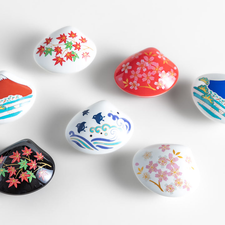 A collection of decorative incense holders shaped like seashells, featuring intricate Japanese-inspired designs, perfect for catching ash while adding elegance.