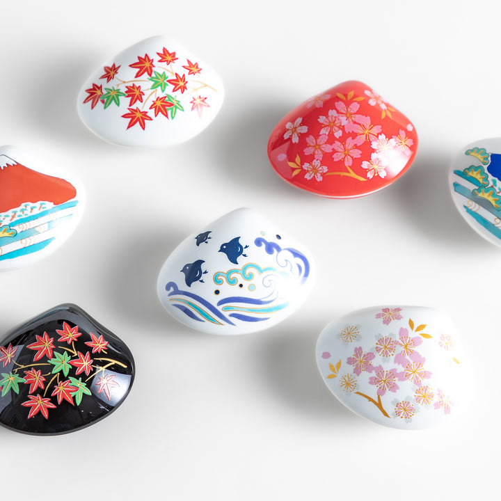 A collection of decorative incense holders shaped like seashells, featuring intricate Japanese-inspired designs, perfect for catching ash while adding elegance.