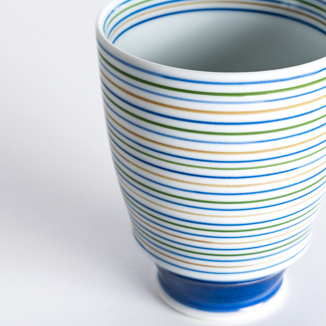 Close-up of the Serene Strip Tea Cup's vibrant striped pattern and glossy finish, focusing on the detailed craftsmanship.