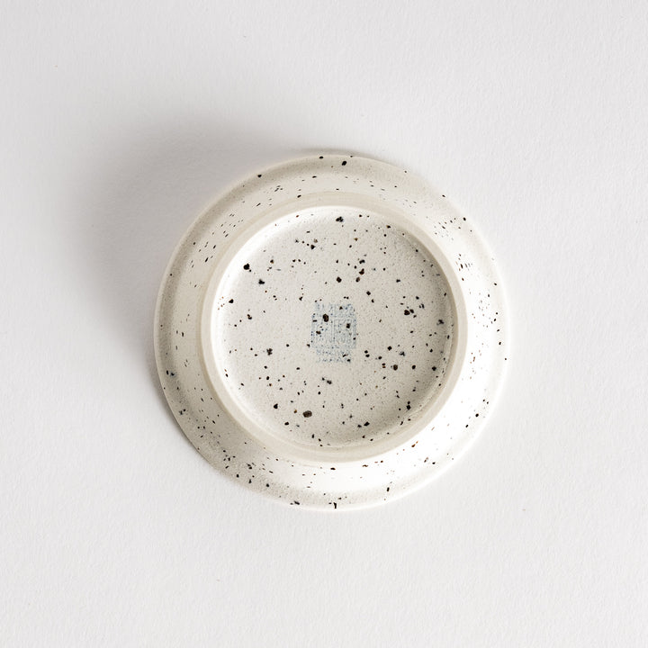 A shallow, off-white dish with a speckled glaze and a slightly textured finish.