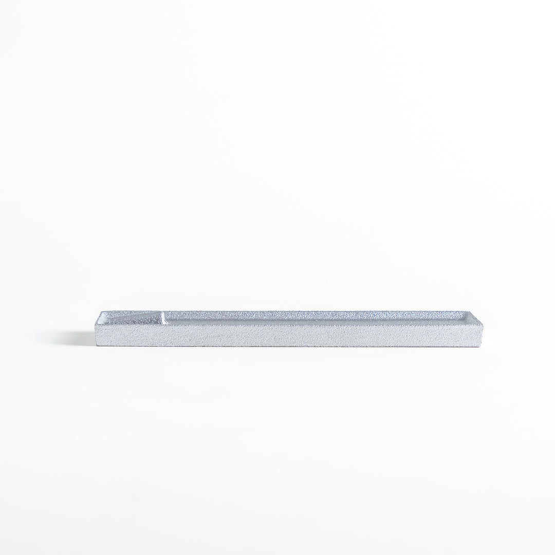 Sleek aluminum incense holder with a modern minimalist design, featuring a rectangular tray and a built-in slot to securely hold incense sticks while catching ash.