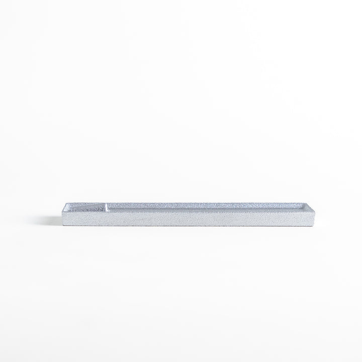 Sleek aluminum incense holder with a modern minimalist design, featuring a rectangular tray and a built-in slot to securely hold incense sticks while catching ash.