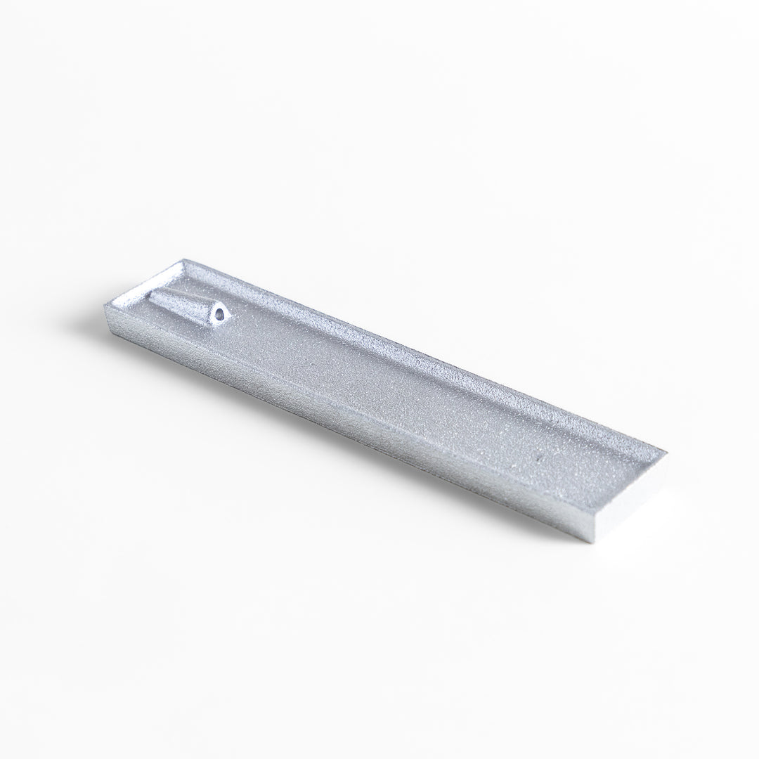 Sleek aluminum incense holder with a modern minimalist design, featuring a rectangular tray and a built-in slot to securely hold incense sticks while catching ash.