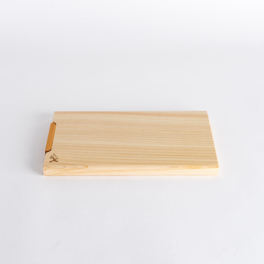 Small hinoki cutting board positioned at an angle, highlighting its elegant and functional shape.