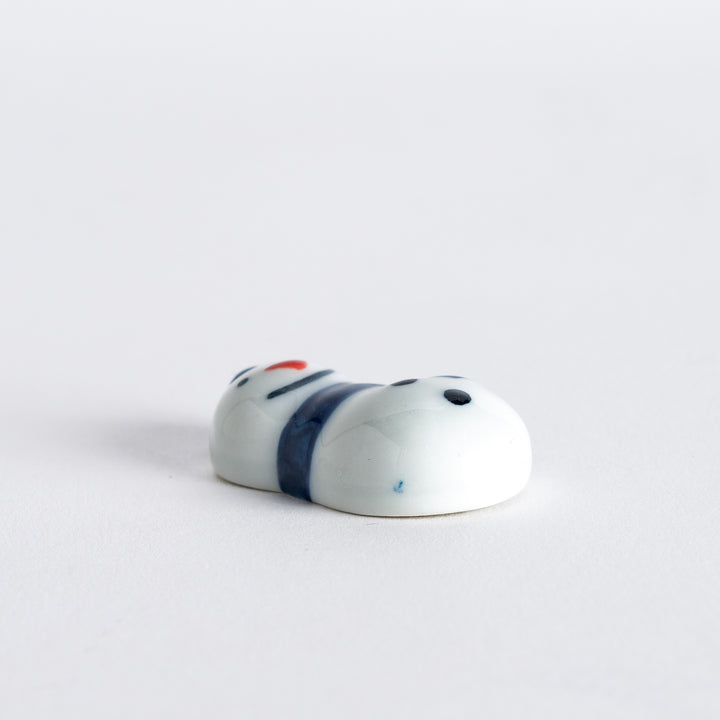 Side view of snowman chopstick rest with a blue hat and scarf, showing off the detailed design in a clean and straightforward way.