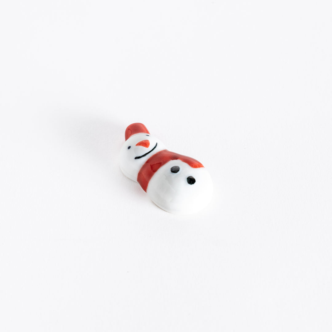 A slightly angled view of the red-scarfed snowman chopstick rest, emphasizing its round shape and charming expression.