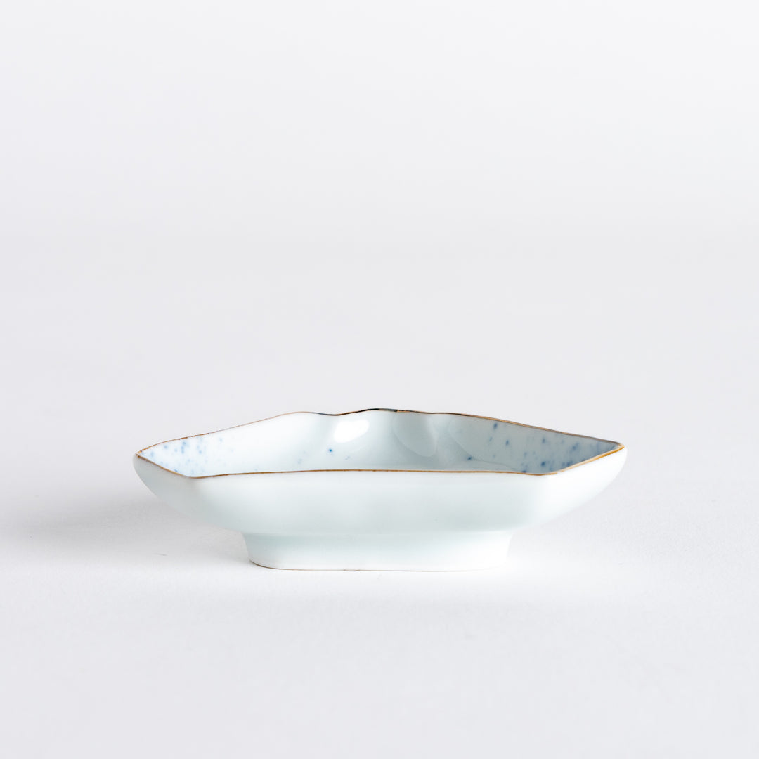 Side view of the mini sauce dish shaped like Mount Fuji, featuring blue speckles and a delicate gold rim along the edges.