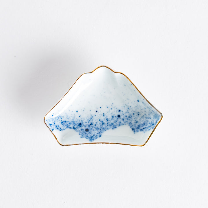 A small sauce dish shaped like Mount Fuji, with a gradient of blue dots resembling the mountain's snowcap.