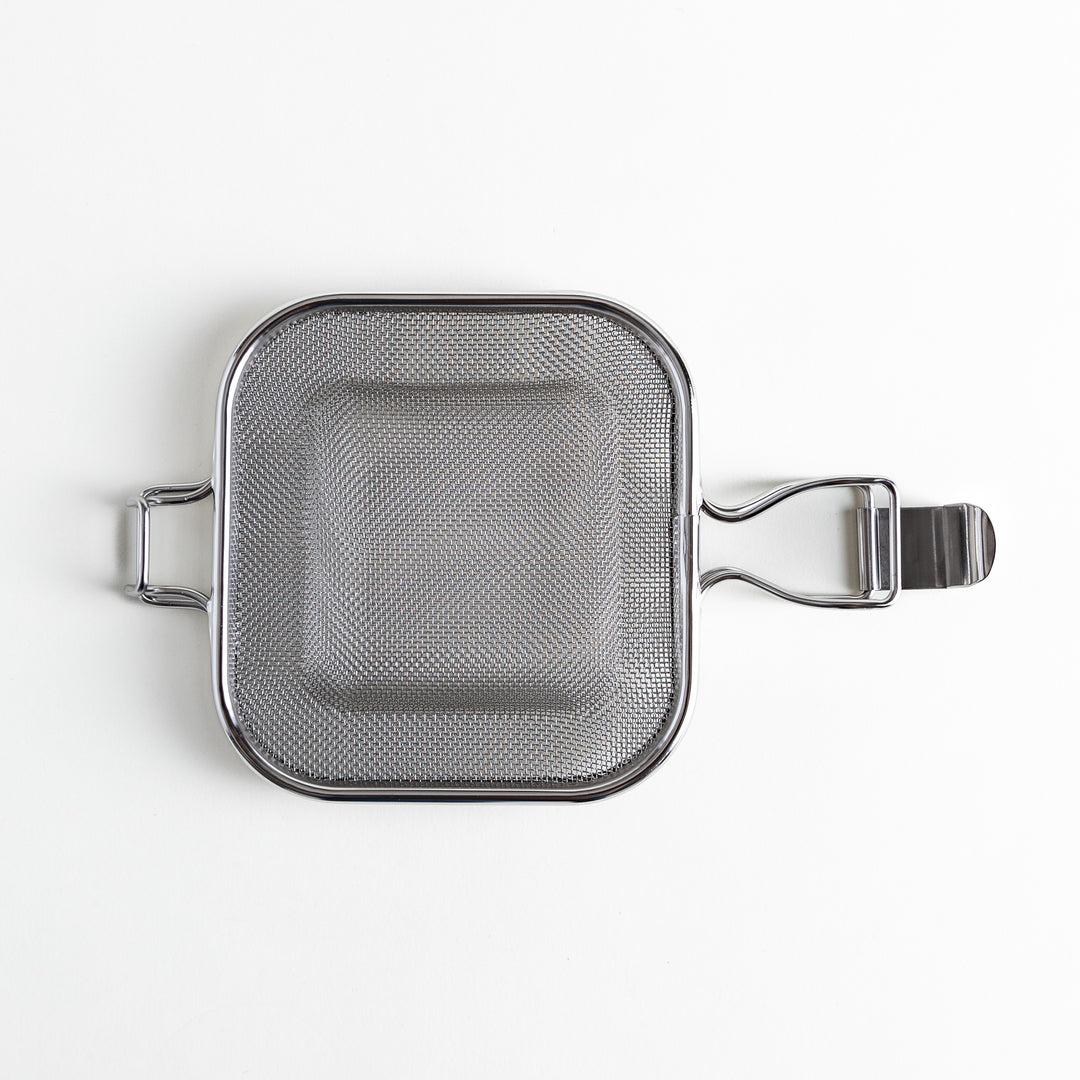 Stainless steel square mesh griller with handles, viewed from above on a plain white background.