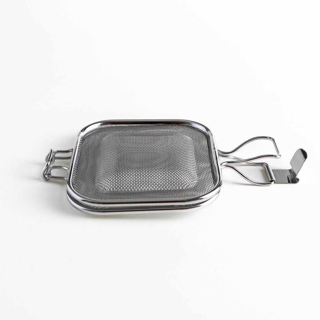 Side view of the closed stainless steel griller, highlighting its compact, stackable design.