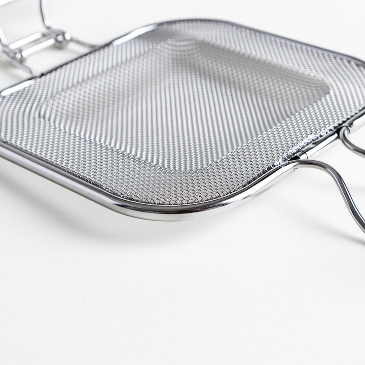 Close-up of the griller’s mesh surface, emphasizing the fine stainless steel weave.