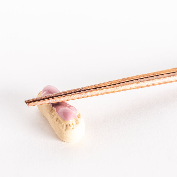 Close-up view of the strawberry éclair chopsticks rest with chopsticks resting on top.