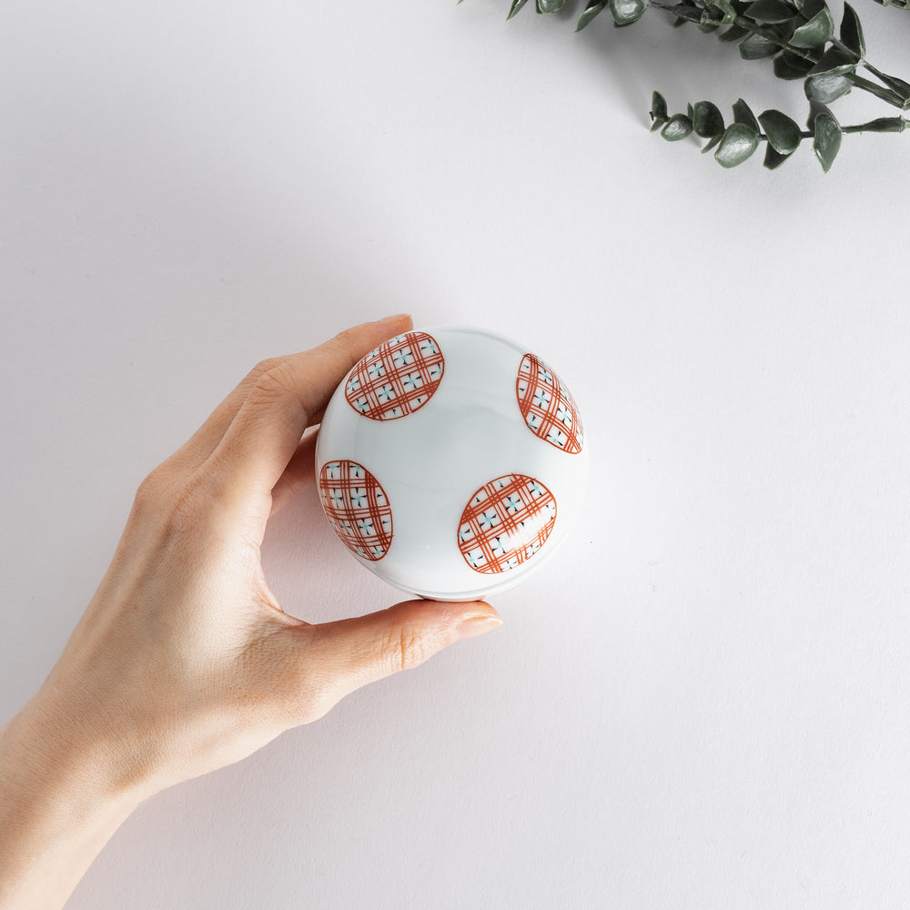 A hand holding the chawanmushi bowl, showcasing its charming design and compact, practical size.