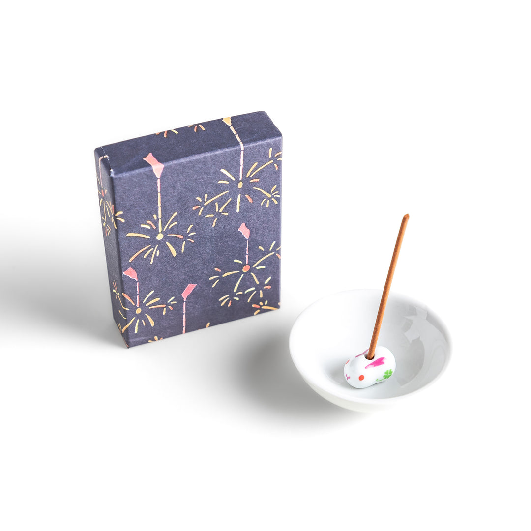 Incense featuring warm brown sticks in a box decorated with a dark blue background and delicate fireworks, evoking a nostalgic summer night atmosphere with a soothing aroma.