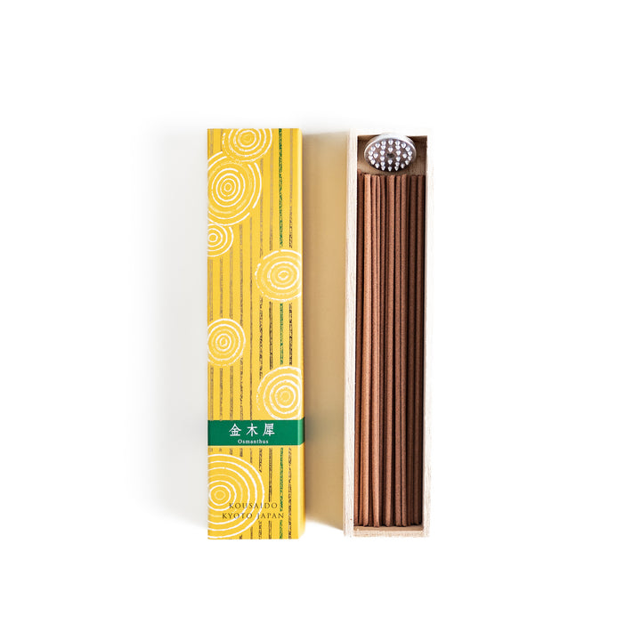 Incense in a light wooden box with warm brown sticks, elegantly packaged in a vibrant yellow design featuring white circular patterns for a refreshing and uplifting ambiance.