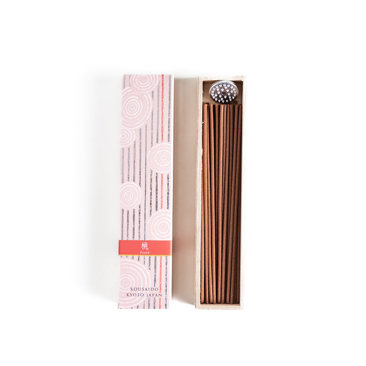 Sweet Peach Incense in a light wooden box with warm brown sticks, elegantly packaged in a soft pink design featuring white circular patterns, evoking a delicate and fruity peach aroma.