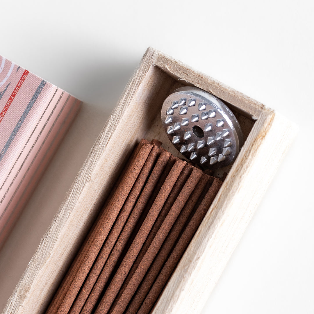 Sweet Peach Incense in a light wooden box with warm brown sticks, elegantly packaged in a soft pink design featuring white circular patterns, evoking a delicate and fruity peach aroma.