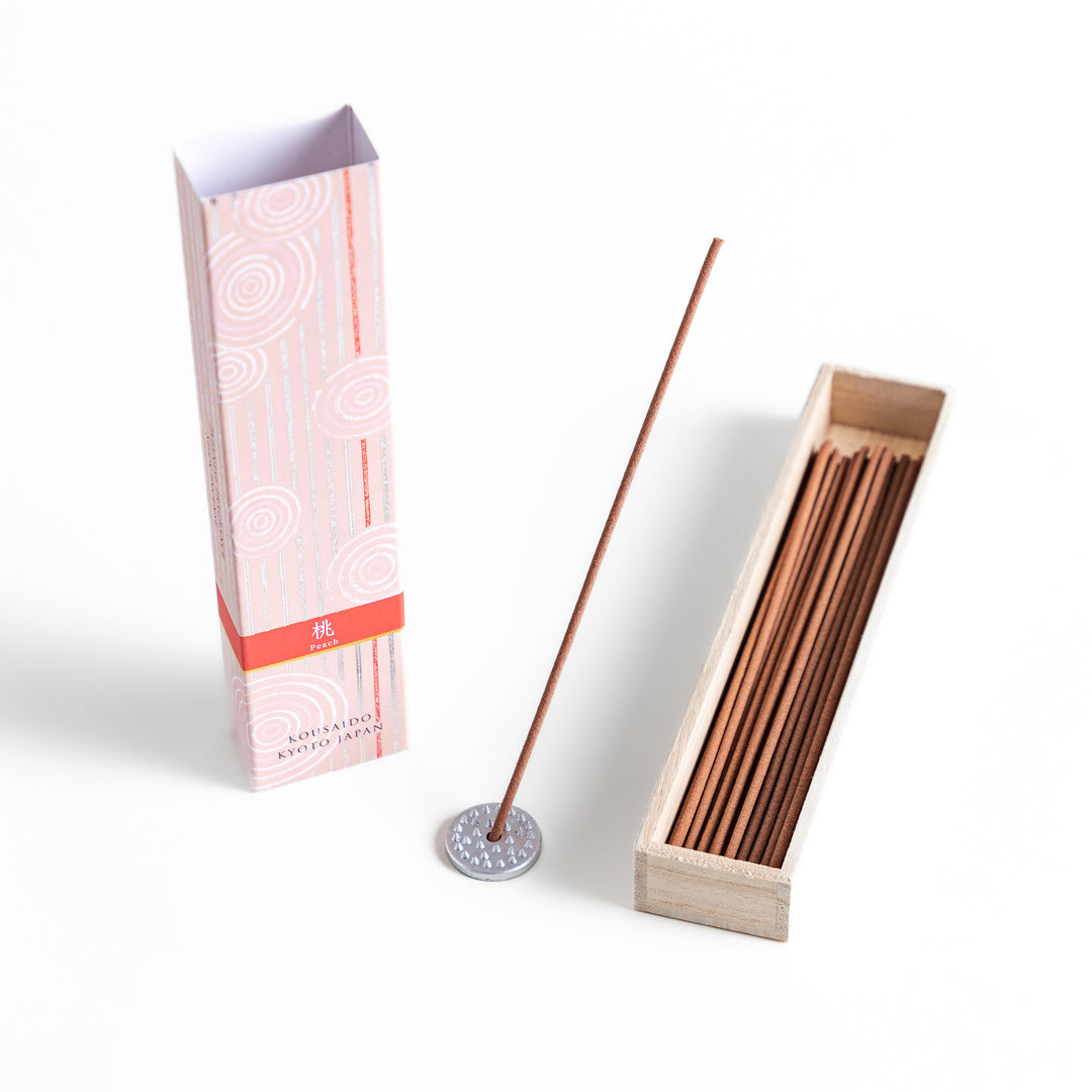 Sweet Peach Incense in a light wooden box with warm brown sticks, elegantly packaged in a soft pink design featuring white circular patterns, evoking a delicate and fruity peach aroma.