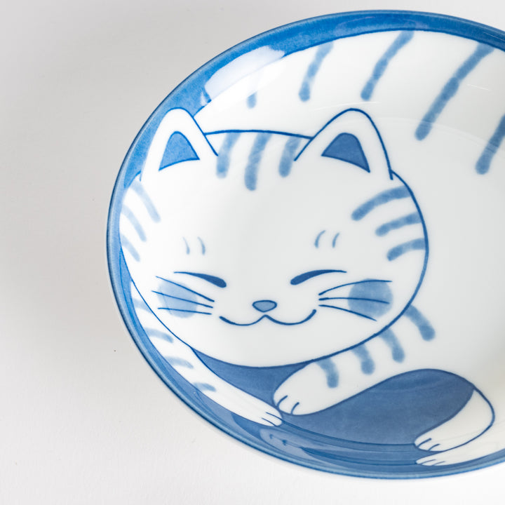 A salad plate with a blue-striped white cat, smiling with closed eyes.