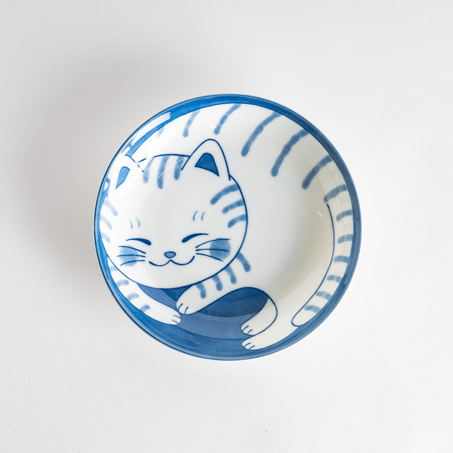 A salad plate with a blue-striped white cat, smiling with closed eyes.