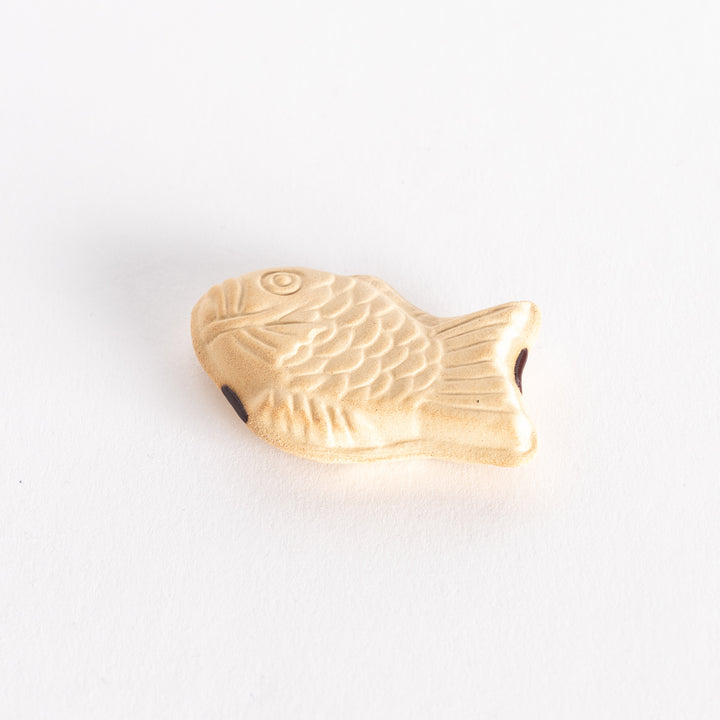 The taiyaki chopsticks rest photographed at a slight angle, showing the fish’s textured details and three-dimensional shape.