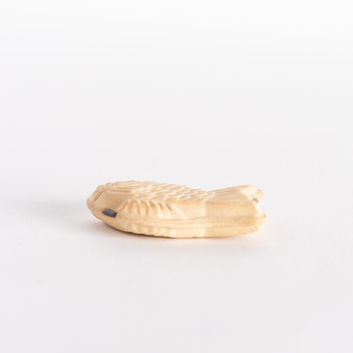 Side view of the taiyaki chopsticks rest, emphasizing its thickness and the raised fish tail design.