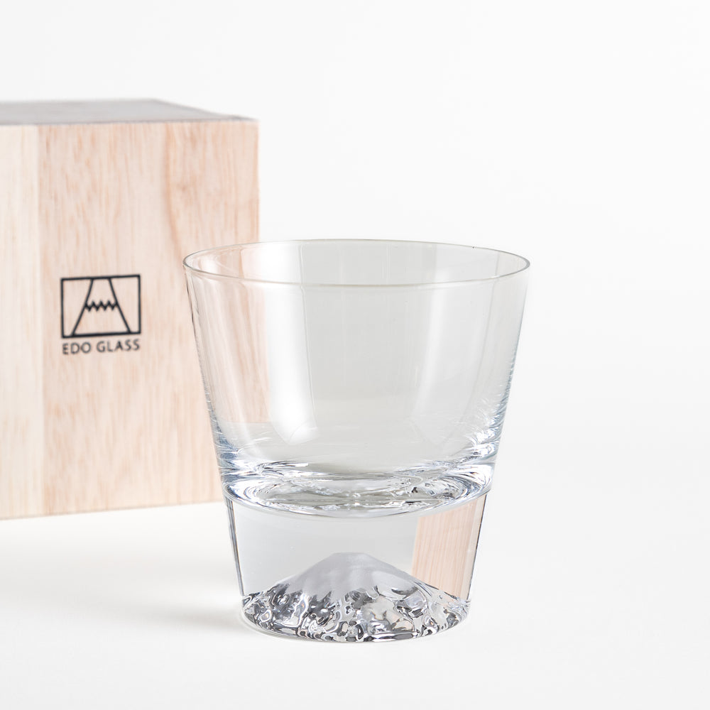 Glass with a mountain-shaped base placed next to the wooden box with the "EDO GLASS" logo. The glass features clear craftsmanship with the mountain base at the bottom.