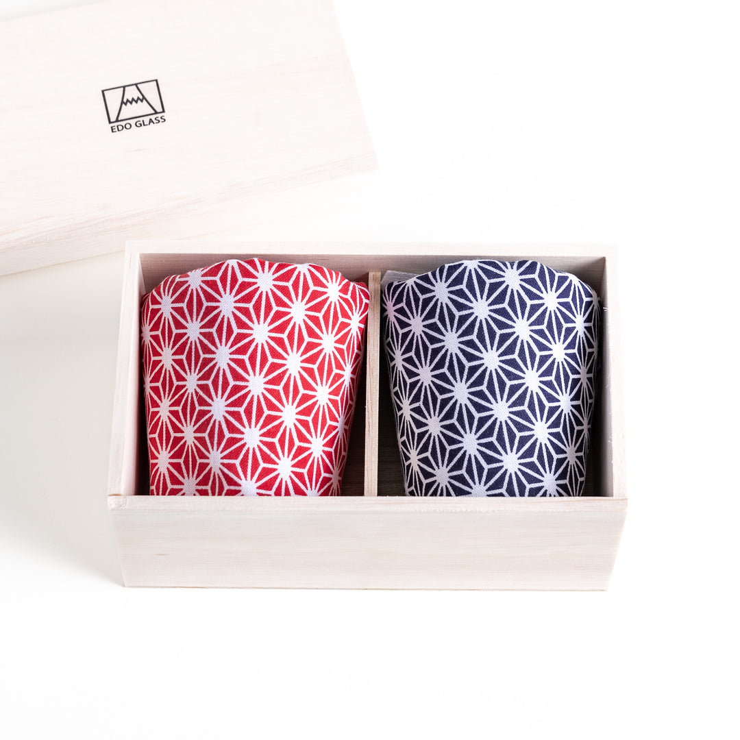 Wooden box with two glasses wrapped in blue and red fabrics printed with geometric-patterns, perfect for gifting or special occasions.