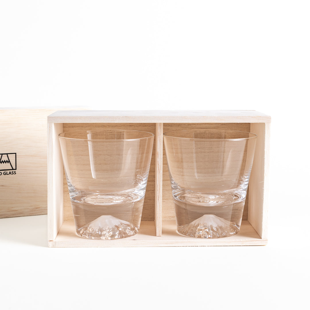 Two glasses placed inside a wooden box with the Edo Glass logo visible on the top of the box. The glasses feature a detailed design resembling Mount Fuji at the base.