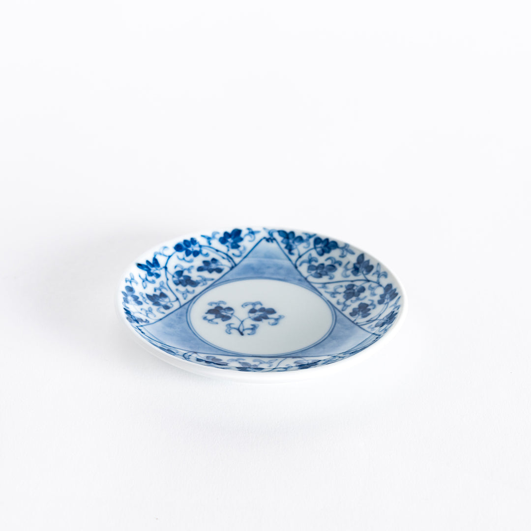 Slightly angled view of the three-sided sauce dish, highlighting the blue arabesque floral pattern along the edges and the central motif.