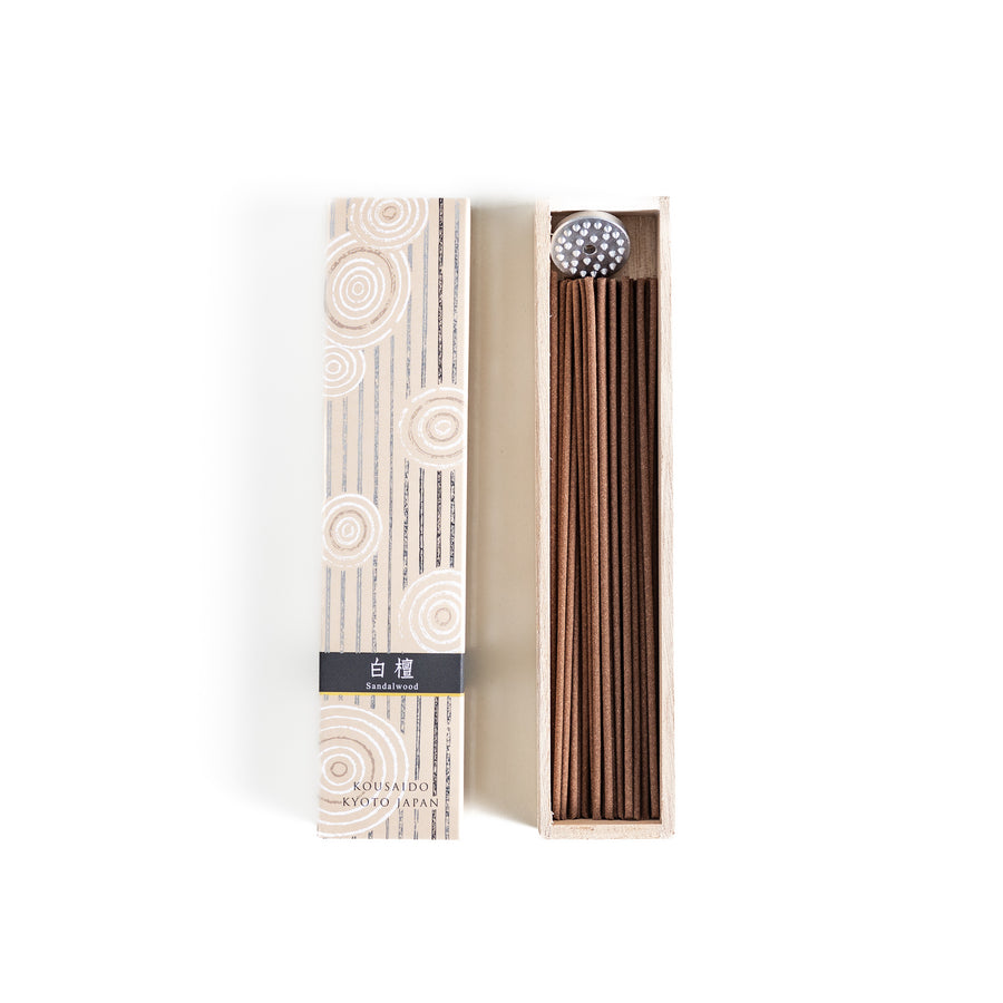 Timeless Sandalwood Incense in a light wooden box with warm brown sticks, elegantly packaged in a soft beige design featuring white circular patterns, evoking a classic and soothing sandalwood aroma.