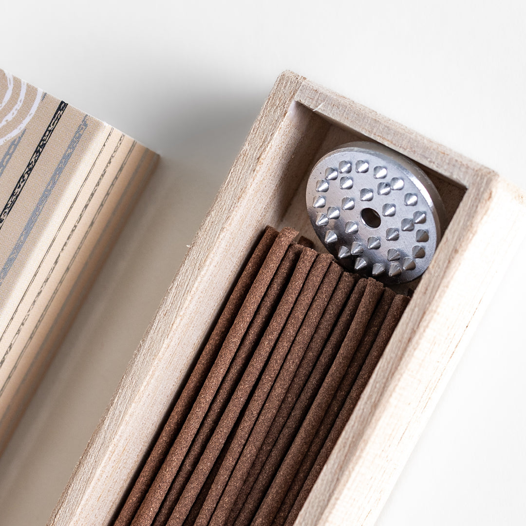 Timeless Sandalwood Incense in a light wooden box with warm brown sticks, elegantly packaged in a soft beige design featuring white circular patterns, evoking a classic and soothing sandalwood aroma.