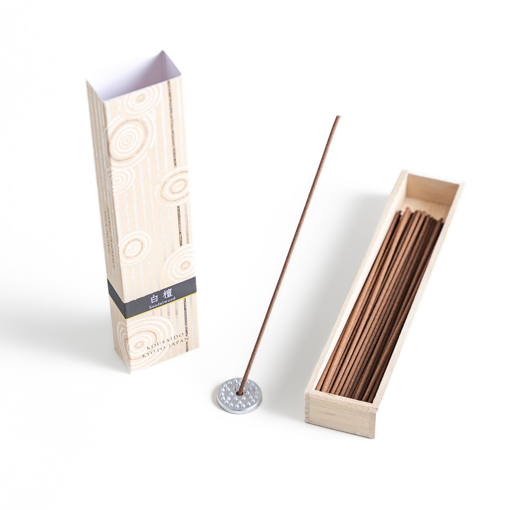 Timeless Sandalwood Incense in a light wooden box with warm brown sticks, elegantly packaged in a soft beige design featuring white circular patterns, evoking a classic and soothing sandalwood aroma.